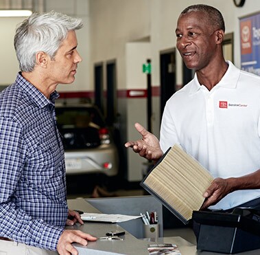  Service technician holding a Toyota genuine engine air filter.